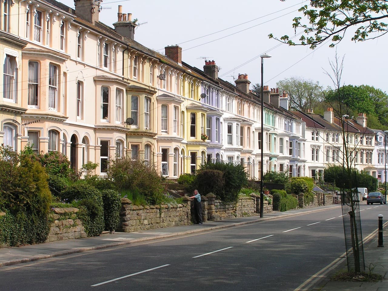 A row of painted Victorian terraces along a quiet residential road